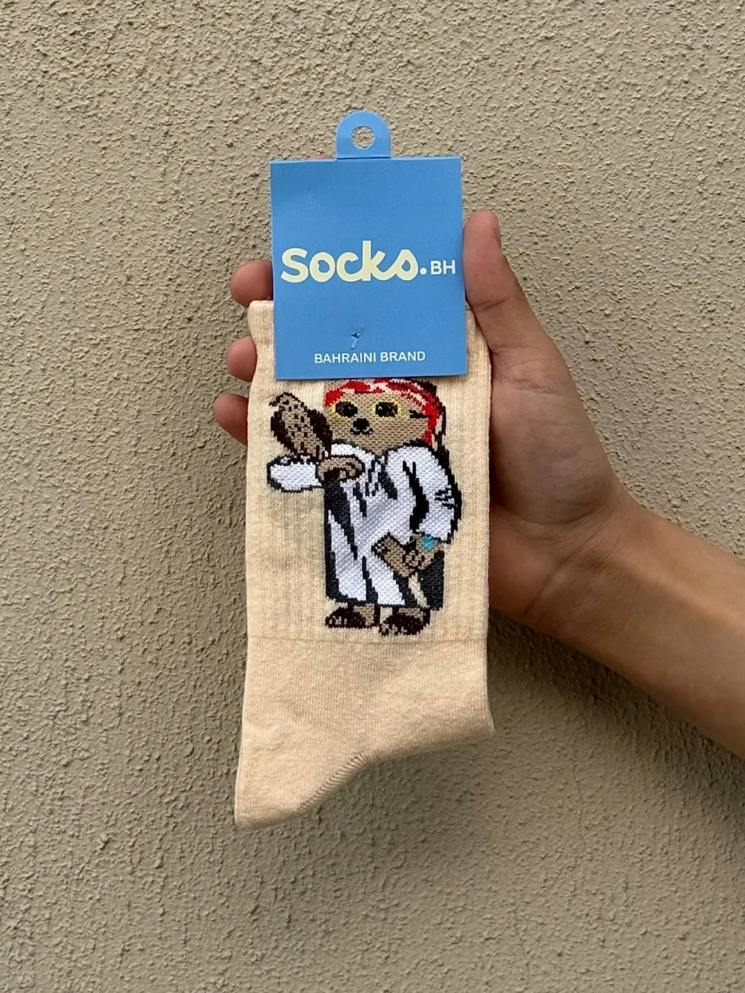 Socks.bh Facebook ad: Desert Style: Pup in Thobe & Shemagh with Falcon Crew Socks